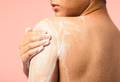 A hand massages a thick white lather of Co-Mingle into their left shoulder. 
