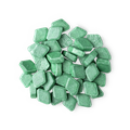 A pile of small, diamond-shaped, green Crème De Menthe mouthwash tabs shot from above.