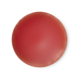 An arial view of orangey, bright red, balm-like Lust solid perfume.