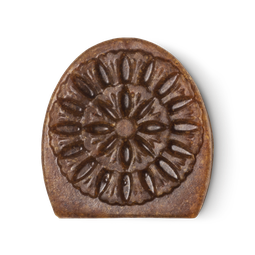 Movis. A brown, semi-oval shaped facial soap with an intricate engraving design.
