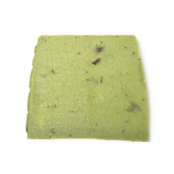 Olive Tree. A lime green, moist looking, trapezium shaped soap, with dark flecks throughout and bumps along its left side.