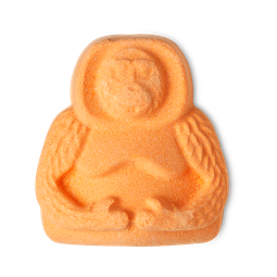 Orangutan bath bomb, a bright orange bath bomb in the shape of an orangutan, sitting with its arms placed across its stomach.