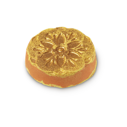 Rangoli Dreams. A circular orange and yellow bath bomb with an embossed top decorated with golden glitter.
