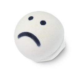 Sad Face, a white, circular-shaped bath bomb with two black dots for eyes and a black frown line.