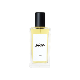 A glass perfume bottle filled with pale yellow liquid. A white label reads 'Shade'.