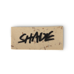 A beigey-cream coloured, rectangular washcard, consisting of apple pulp, with 'Shade' written across it in black Lush writing.