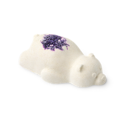 Sleepy Bear, a bath bomb in the shape of a bear sleeping on its belly with a sprinkling of lavender flowers on its back.