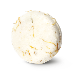 Soak and Float. A cream coloured, circular solid shampoo bar, with dried marigold petals pressed within.