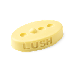 Therapy. A buttery yellow, oval shaped, solid massage bar, with a design of 3 small holes cut out with 1 bump in a line.