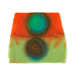Alban Elfed. A thick, colourful soap slice with the top half a deep red colour with an emerald green circle. The bottom half is inverted colours with a main colour of green and a dark red circle.