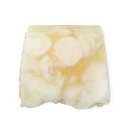Bohemian. A light yellow, creamy swirled, smooth, trapezium shaped soap, with bumps along its left side.