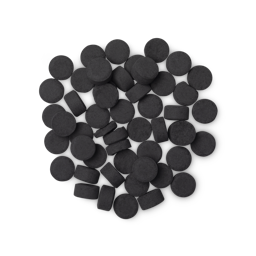 A pile of small, circular, black Boom! toothpaste tabs shot from above. 