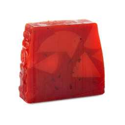 Christmas Cranberry. A trapezium-shaped, partially translucent, deep red soap with flecks of black and bumpy side.