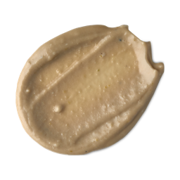 Enzynamite. A round, smudged swatch of pale, golden, creamy face mask with visible textured exfoliating pieces.