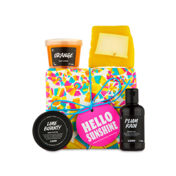 Hello Sunshine. A fun, bright-coloured, wrapped box tied with blue string. Four LUSH products including a soap, body scrub, body butter and shower gel sit around and on top of the box. 