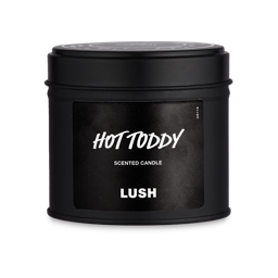 Hot Toddy. The image shows the complete Hot Toddy single-wick candle product packaging. A circular, black-tin pot with removable lit. A black sticker on the front reads "Hot Toddy" in white LUSH font. 