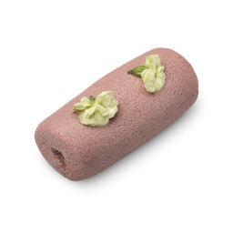 Illipe of Faith. A light pink, cylindrical sugar cleanser roll with a granular texture and topped with fresh white flowers.