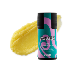 Magik. A thick, black, twist-up temple balm stick with a pink and turquoise label sits in front of a smeared swatch of creamy, honey-coloured temple balm product. 