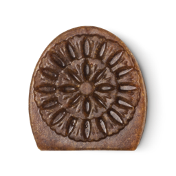 Movis. A brown, semi-oval shaped facial soap with an intricate engraving design.