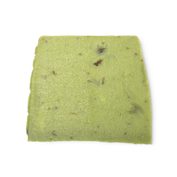 Olive Tree. A lime green, moist looking, trapezium shaped soap, with dark flecks throughout and bumps along its left side.