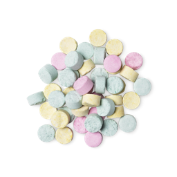 A pile of small, circular, multicoloured Refresher toothpaste tabs shot from above. 