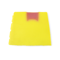 Rhubarb and Custard. A bright yellow, trapezium shaped soap, with bumps along its left side and a little pink section on top.