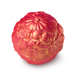 Rose Gold. A round bath bomb, rose coloured, with an ornate floral design on top, dusted with gold. 