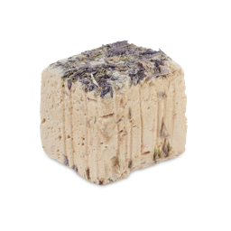 Snow Fairy. A rounded cube-shaped facial wash. The product is a creamy beige colour with an almost marshmallow texture. Dried violet flowers are pressed into the top of the product cube. 