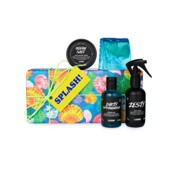 Splash! A gift box wrapped in colourful shell-patterned paper and tied with green string. Four LUSH products including a soap, body spray, body scrub and shower gel sit around and on top of the box. 