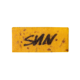 A light orange, rectangular washcard, consisting of apple pulp, with 'Sun' written across it in black Lush writing.