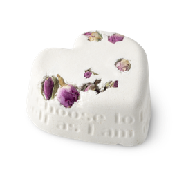 Tisty Tosty. A white, heart shaped bath bomb, topped with dried rosebuds, and a loving inscription running along its side edge.