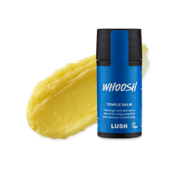 Whoosh. A smudged swatch of thick, natural yellow balm. In front of it stands the cylindrical black packaged Temple Balm with an electric blue product sticker. 