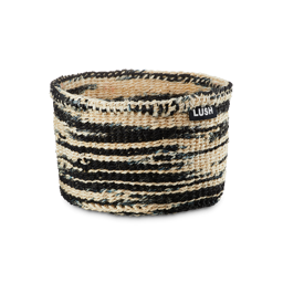 Handwoven basked. A mix of black and neutral beige fibres make up a small, neat hand-woven basket with a small LUSH tag.