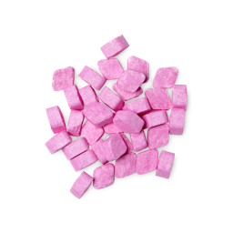 A pile of small, diamond-shaped, pink Zing! mouthwash tabs shot from above.